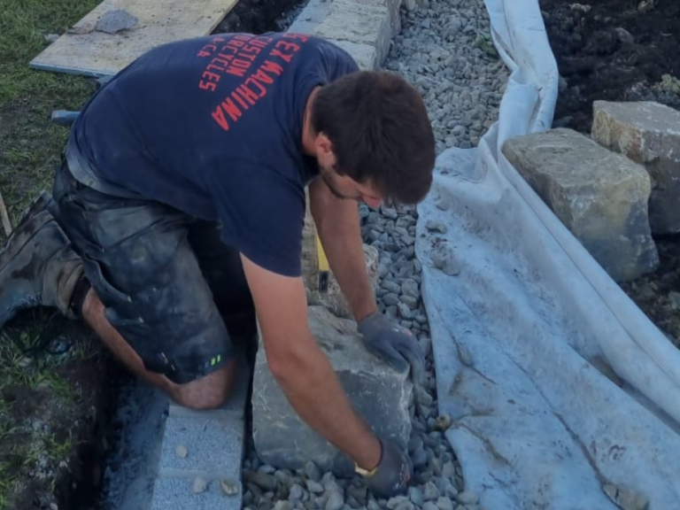 Bau der Trockensteinmauer aus Muschelkalk auf Schotterpackung mit integrierter Drainage