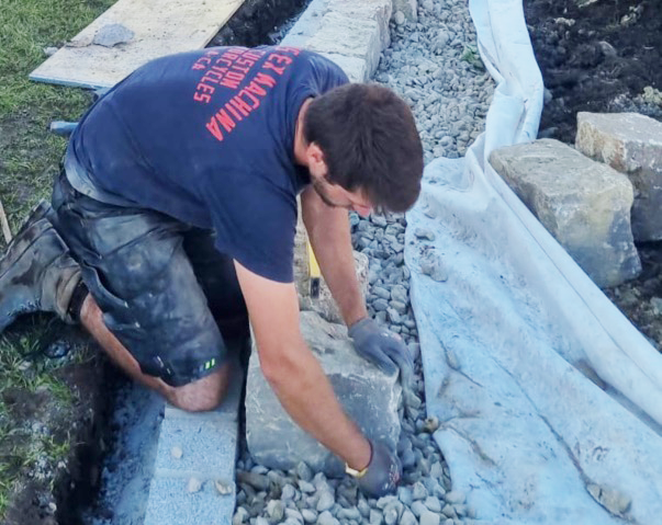 Bau der Trockensteinmauer aus Muschelkalk auf Schotterpackung mit integrierter Drainage
