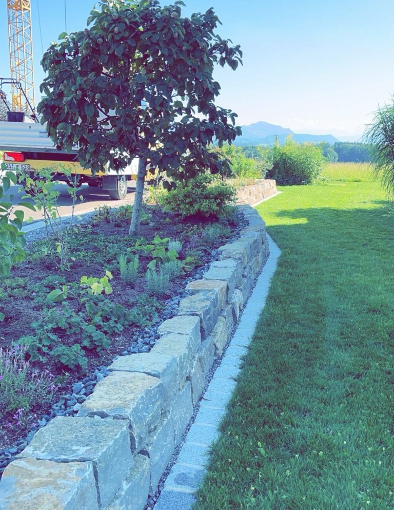 Privatgartenanlage mit Muschelkalkmauer, davor Graniteinzeiler mit Staudenbeet